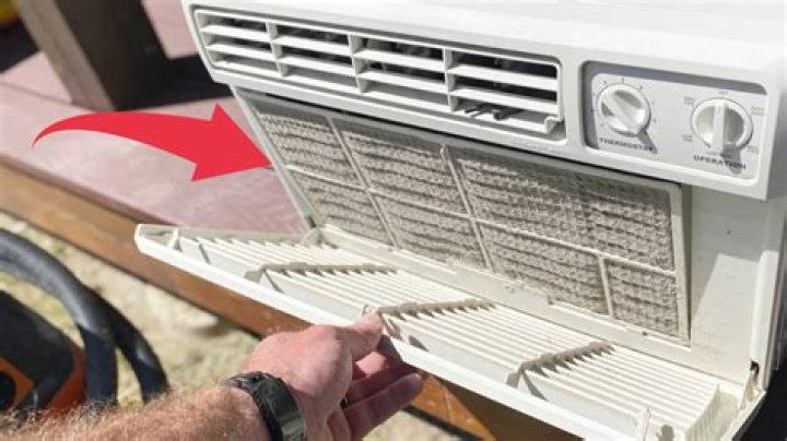 How do you clean a window air conditioner without removing it?